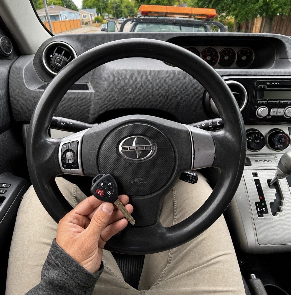 Scion in-cabin key replacement with tow truck in the background